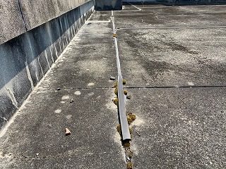 学校の屋上の床とパラペットの状況。床のモルタル。その下にアスファルト防水層が施工されていることが竣工図面からわかっている。床の目地は伸縮性がある樹脂製。